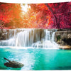 A panoramic photograph of a vibrant waterfall cascading into a clear turquoise pool surrounded by lush red and orange foliage