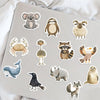 A collection of assorted animal stickers featuring various wildlife designs on a gray surface.
