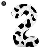 A large white foil balloon shaped like the number 9 with a black cow print pattern.