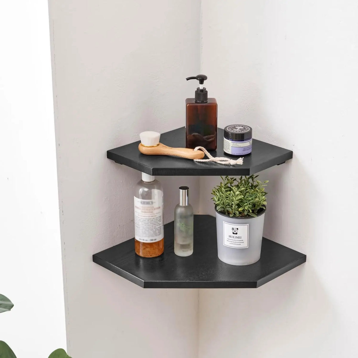 A set of two black wall-mounted corner shelves displaying natural wood and glass skincare products.