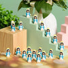 A set of 20 classic blue mini figurines with white hair and green accents arranged on a light green staircase.