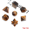 A set of seven geometric crystal shapes made of dark brown stone, including a cube, pyramid, and sphere.