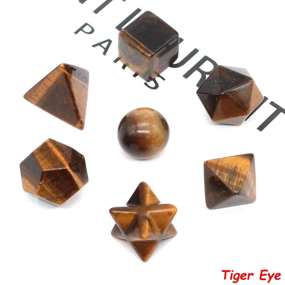 A set of seven geometric crystal shapes made of dark brown stone, including a cube, pyramid, and sphere.
