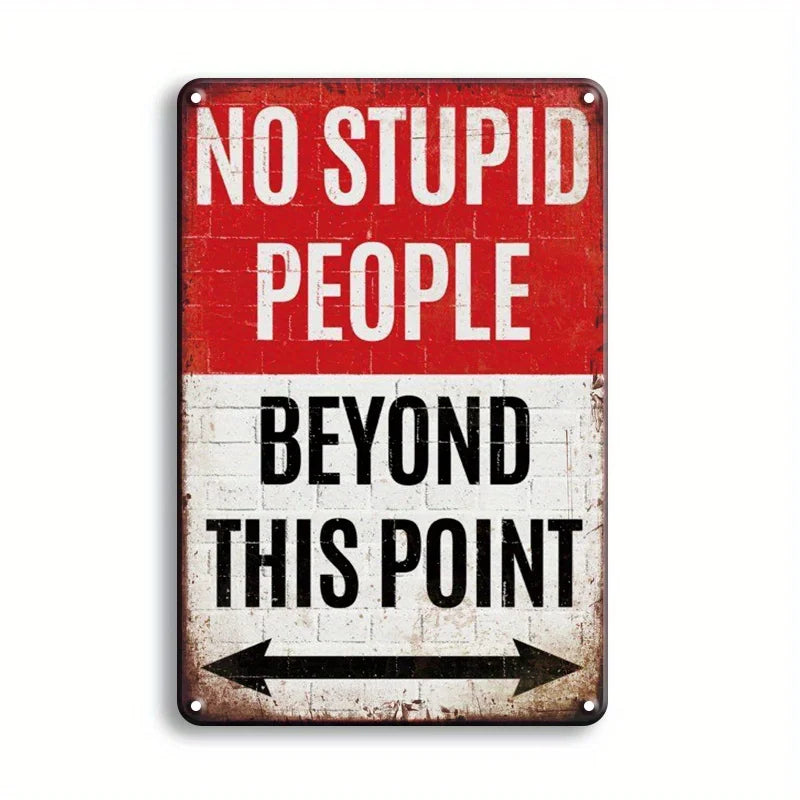 A vintage metal tin sign with red and white text that reads NO STUPID PEOPLE BEYOND THIS POINT.