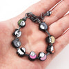 A silver charm bracelet featuring miniature figures of Itadori, Fushiguro, and Gojo from Jujutsu Kaisen.