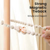 Two magnetic wooden bead curtain tiebacks with a decorative clasp are shown against a light-colored curtain.
