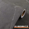 Roll of matte marble self-adhesive waterproof wallpaper being unrolled on a dark surface