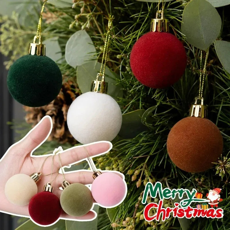 A hand holds five velvet flocked Christmas ornaments in various colors like green, white, pink, and brown against a green pin