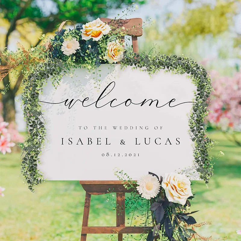 Panneau en bois rustique décoré d'une guirlande d'eucalyptus vert, souhaitant la bienvenue aux invités du mariage d'Isabel & 