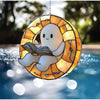 A round window hanging decoration shaped like a ghost with a smiling face, featuring an open book design.
