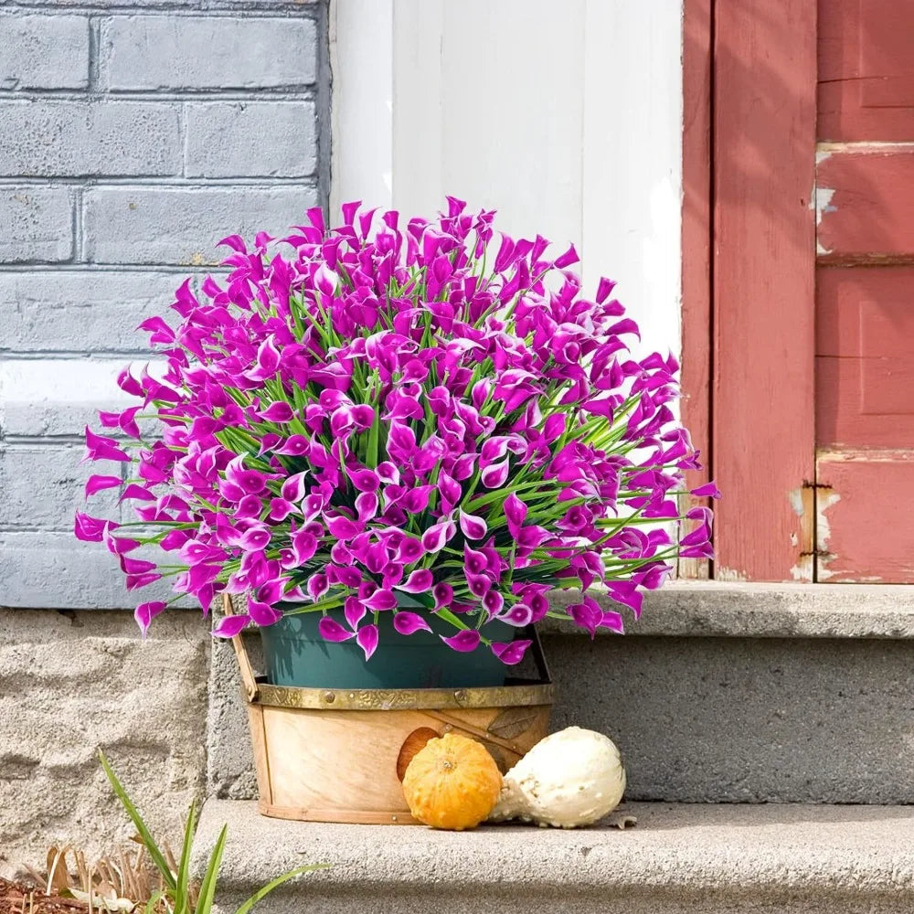 A vibrant bouquet of purple artificial calla lilies in a green pot sits on stone steps next to a pink wooden door.