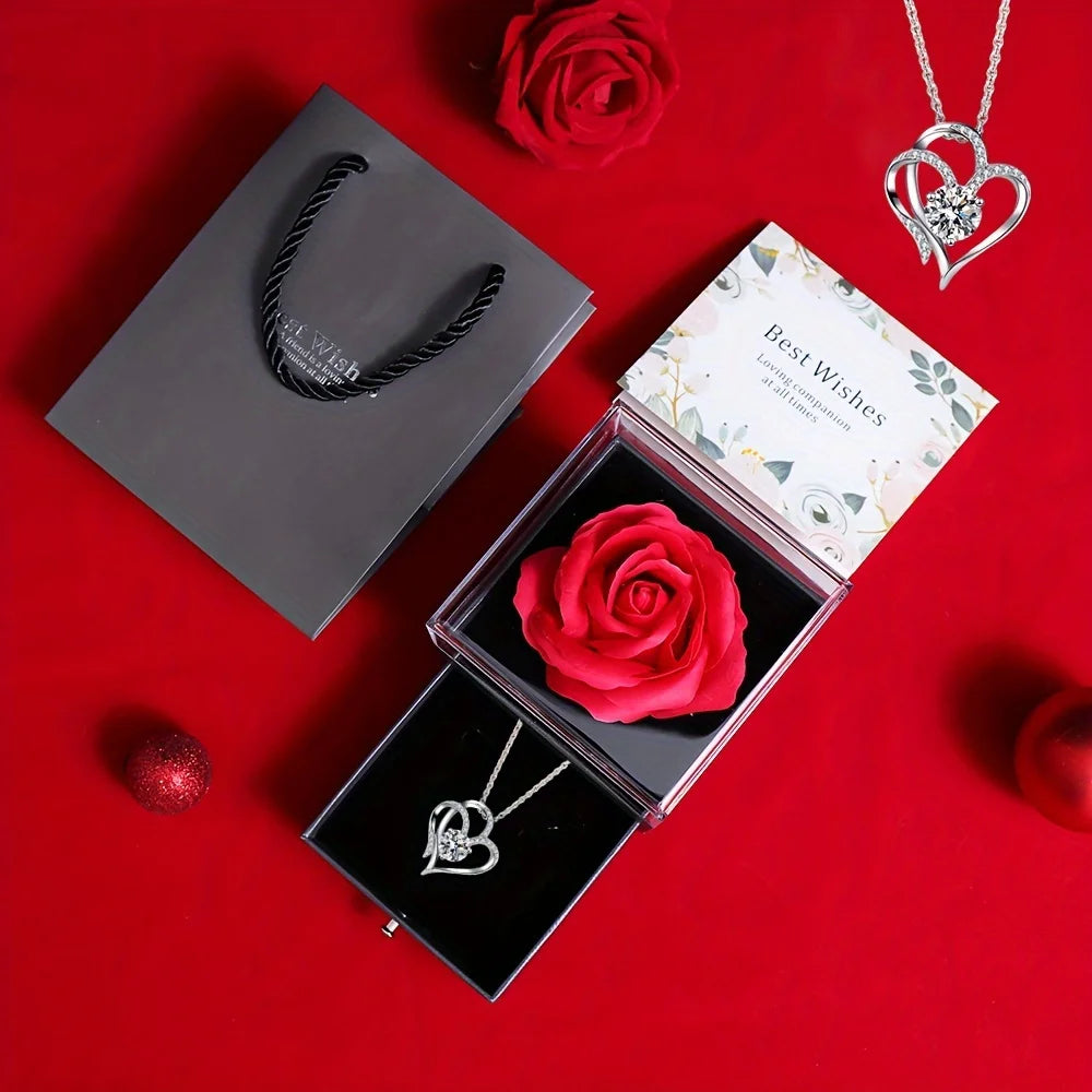 A gift set featuring a preserved red rose and a silver heart-shaped necklace displayed on a red background.