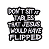Black enamel pin with white text that reads Don't sit at tables that Jesus would have flipped