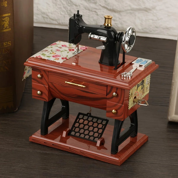 A vintage clockwork music box featuring a black iron and silver mechanism displayed on a wooden desk.