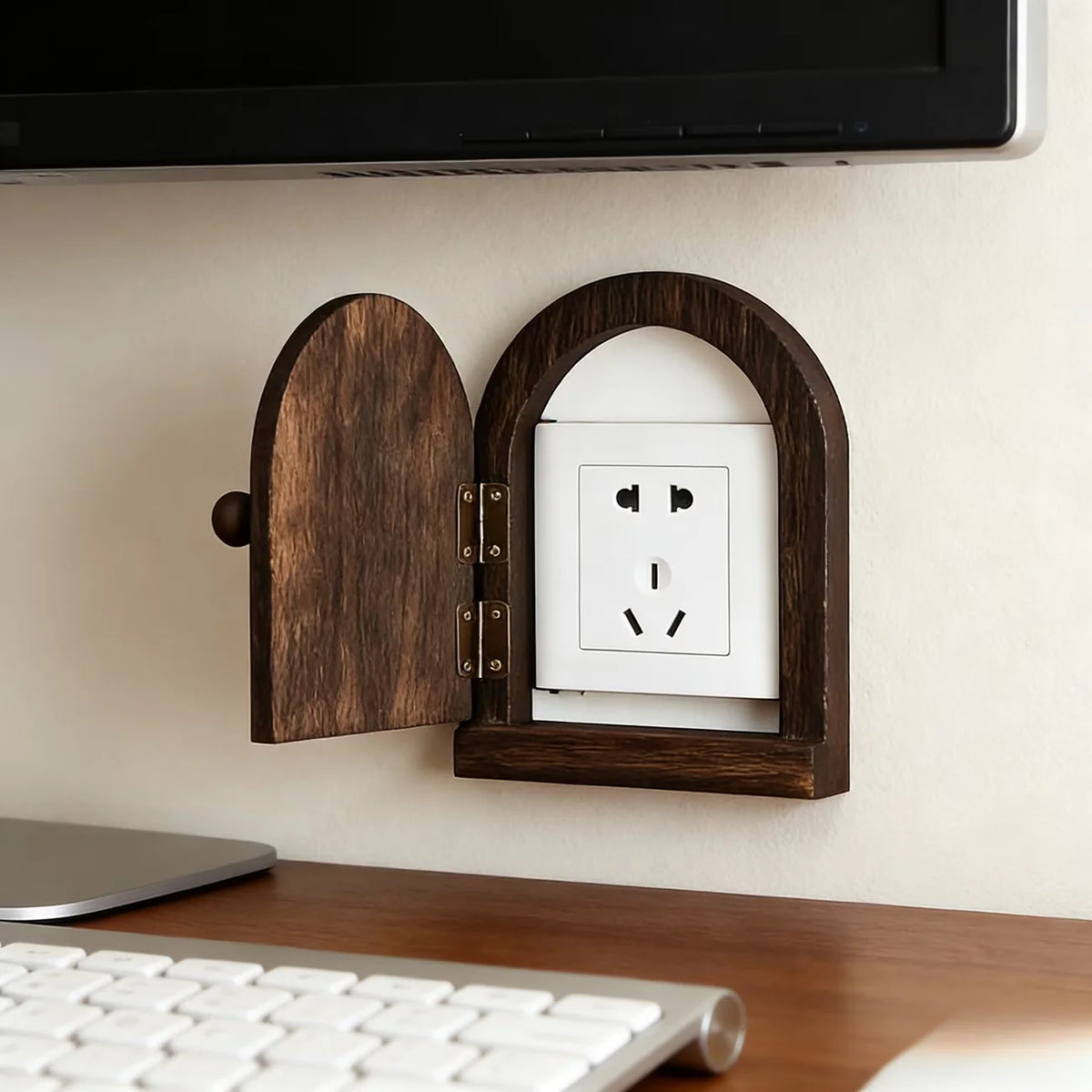 A wooden decorative outlet cover is mounted on a wall, featuring an arched opening to reveal a white electrical outlet.