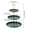 A two-tier serving stand with gold accents, featuring dark green, scalloped plates for desserts or fruit.