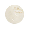 A round, translucent light sign with the text Hello World and a hand outline etched on it.
