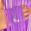 Hand holding purple metallic tinsel foil fringe curtain strands