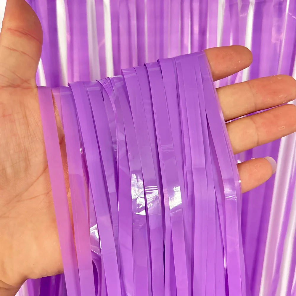 Hand holding purple metallic tinsel foil fringe curtain strands