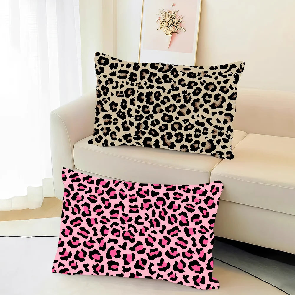 A pink leopard print decorative pillow cover resting on a white sofa.