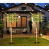 Artificial golden palm trees with lights decorating a backyard patio area at dusk.