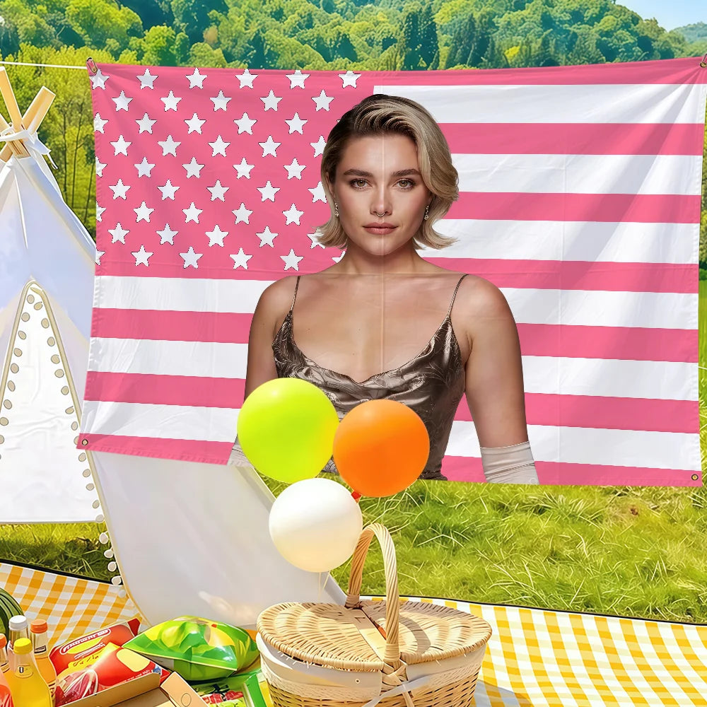 A woman stands in front of a pink and white American flag banner with stars, holding bright yellow and orange balloons.