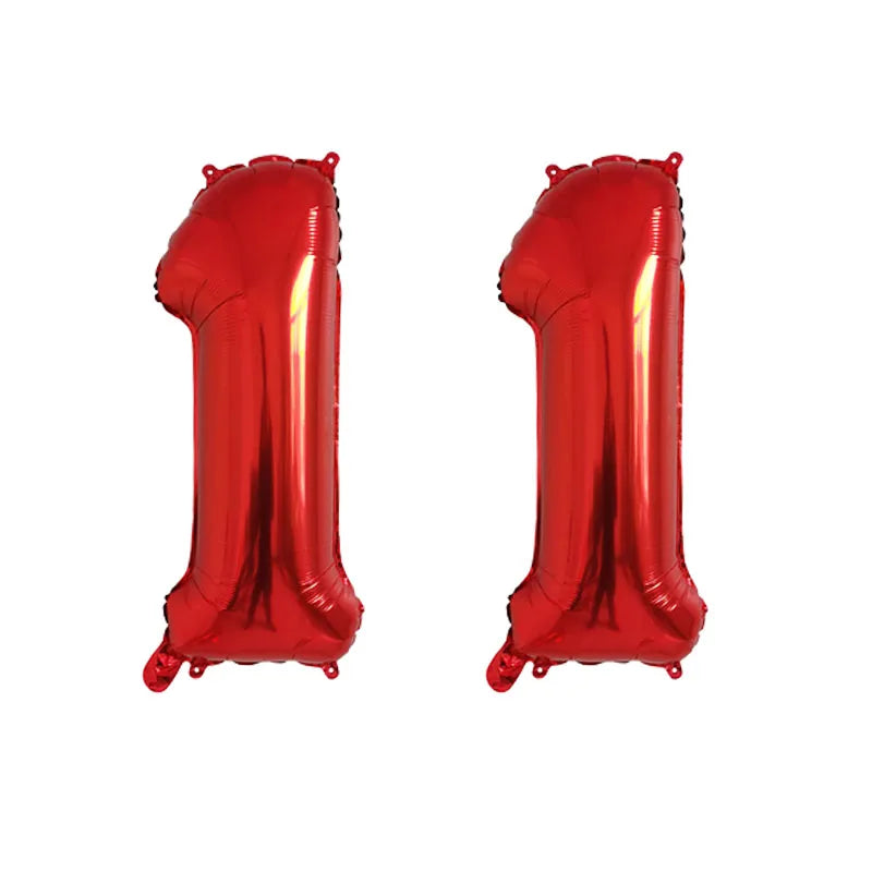 Two shiny red foil number balloons shaped like the number 1, used for birthday party decor.