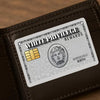 A brown leather wallet features a white privilege rewards card with an engraved portrait and decorative border.