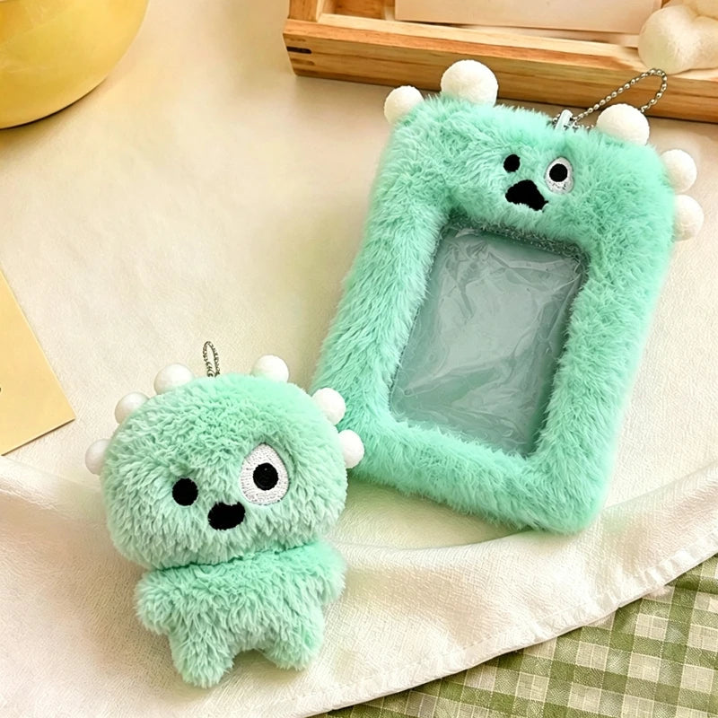A light green fluffy plush keychain shaped like a small creature with a clear plastic holder for photos