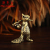 A vintage brass squirrel figurine standing on a dark wooden surface.