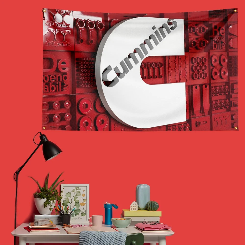 A red banner featuring the Cummins logo on a textured background, displayed on a wall.