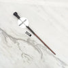 A black metal magic wand replica with a metal core is displayed on a white marble surface.