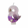 A large number eight candle decorated with purple glitter and a starfish design.