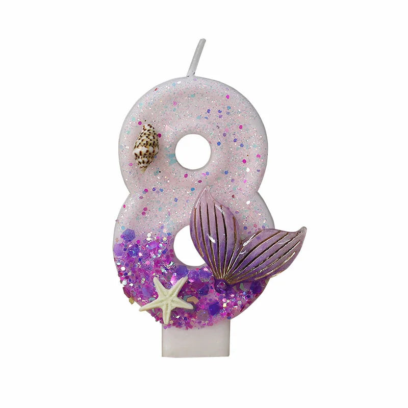 A large number eight candle decorated with purple glitter and a starfish design.