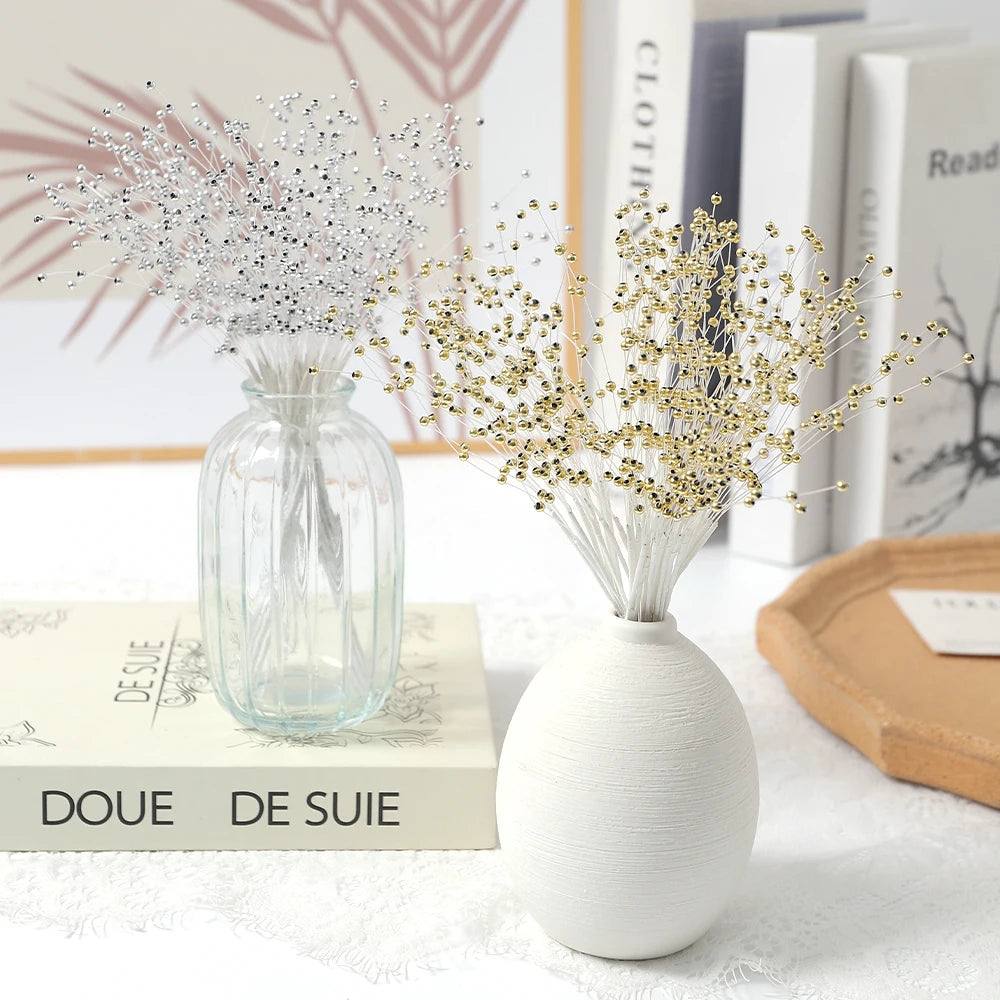 A glass vase holds a bouquet of gold pearl string beads for wedding and DIY decor.
