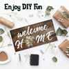A wooden sign with the text welcome home is displayed on a white background surrounded by crafting tools and greenery.
