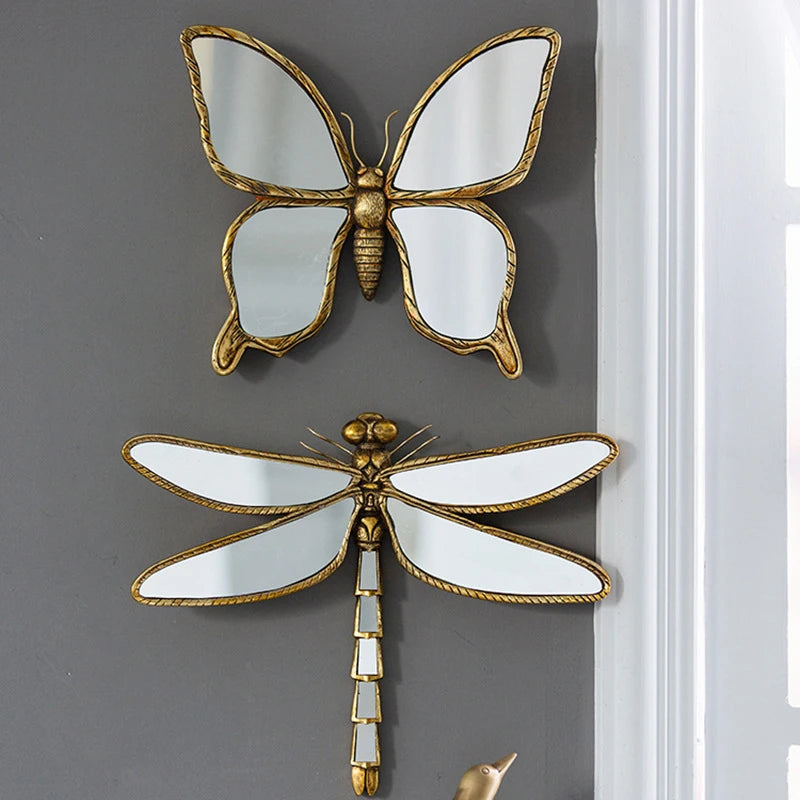 An artisan butterfly wall mirror featuring a gold antique frame and reflective wings.
