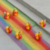 A set of mini resin colorful duck decorations arranged on a rainbow-colored background.