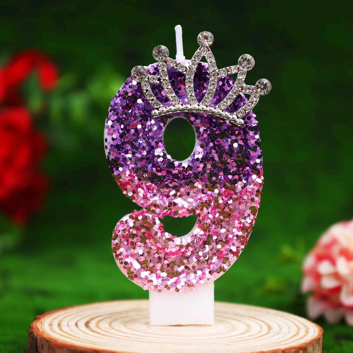 Glitter number 9 birthday candle with rhinestone crown cake topper on a white stand