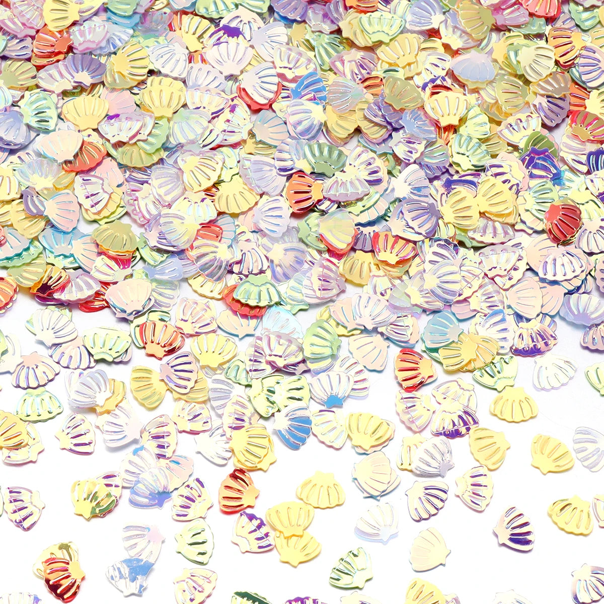 A close-up of iridescent sea shell PVC sequins in various pastel colors scattered on a white background.