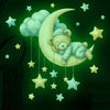 Autocollant mural ours en peluche phosphorescent avec une lune et des étoiles sur fond vert foncé.