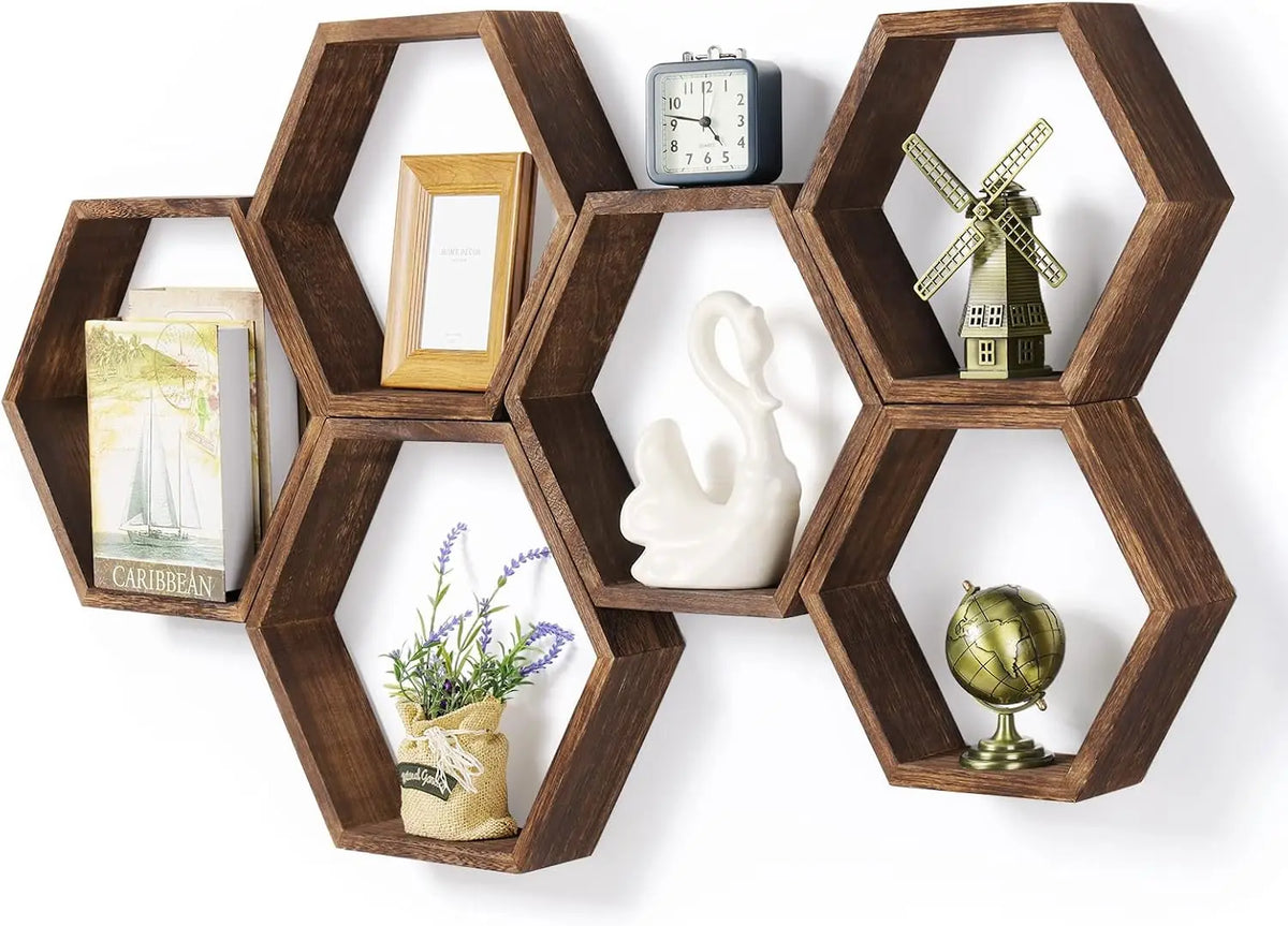 A set of four hexagonal wooden floating shelves displaying decorative items like a clock, sailboat, windmill, and globe.