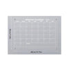 A monthly planner grid displayed on a silver magnetic acrylic board with labeled days and notes section.