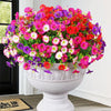 A vibrant bouquet of artificial silk cloth flowers in shades of pink, red, and purple displayed in a white urn.