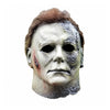 A realistic latex mask of Michael Myers featuring a pale face and bloody scar details.