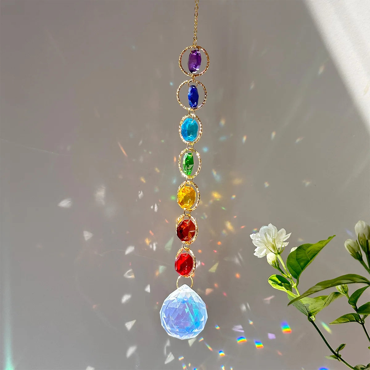 A long necklace featuring colorful crystal prisms and a large blue crystal pendant catching sunlight.