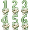 A set of vintage green foil balloons shaped like the numbers 1 through 6 for birthday decor