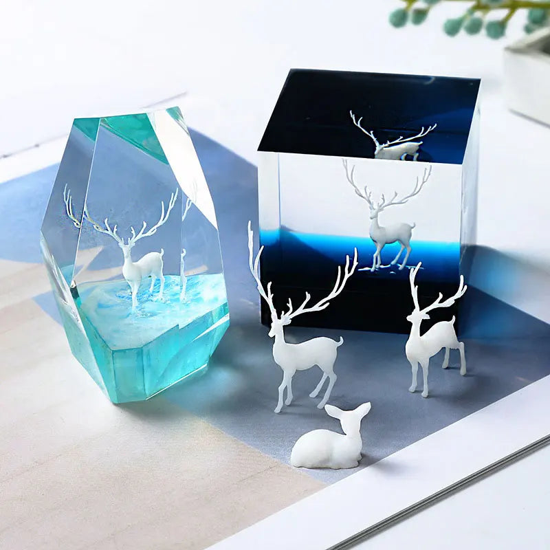 Mini elk deer resin landscape ornament displayed in a clear blue crystal and a dark square box.