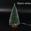Warm white LED mini Christmas tree with a snow effect, featuring a green pine tree on a wooden base.