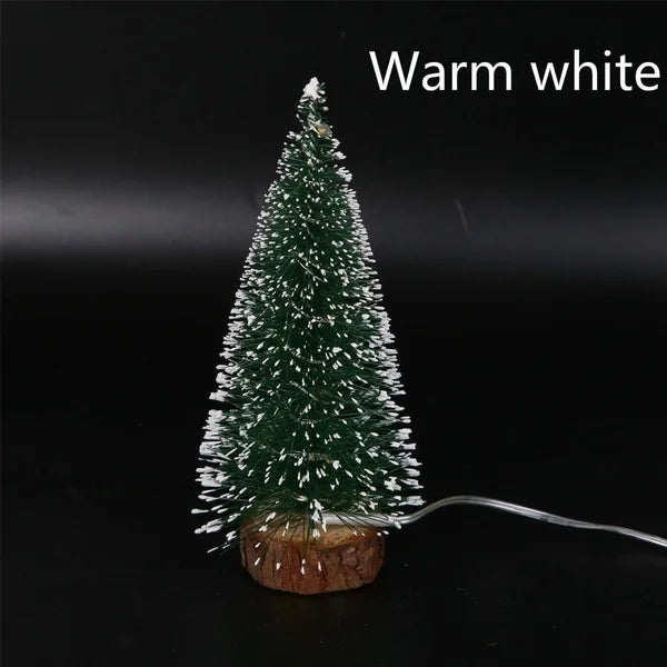 Warm white LED mini Christmas tree with a snow effect, featuring a green pine tree on a wooden base.